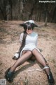 A woman in a white dress sitting on the ground.