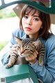 A woman holding a cat in her arms.