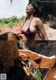 A woman in a red bikini posing on a rock.