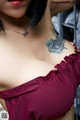 A woman with a tattoo on her chest and a necklace.