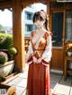 A woman in a red and white kimono standing on a patio.