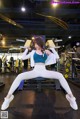 A woman sitting on a bench in a gym.